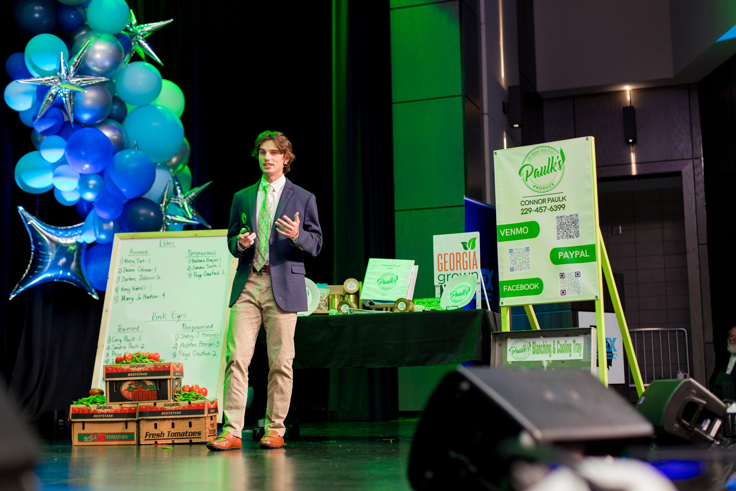 a student stands in front of boards to pitch his business plan.