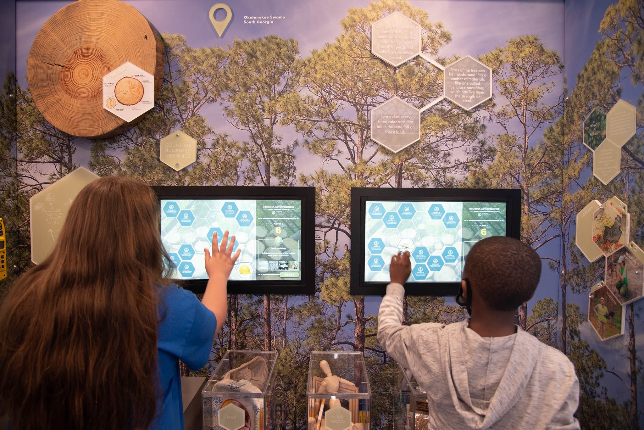 Two children work on iPads to practice farming activities in the metaverse.