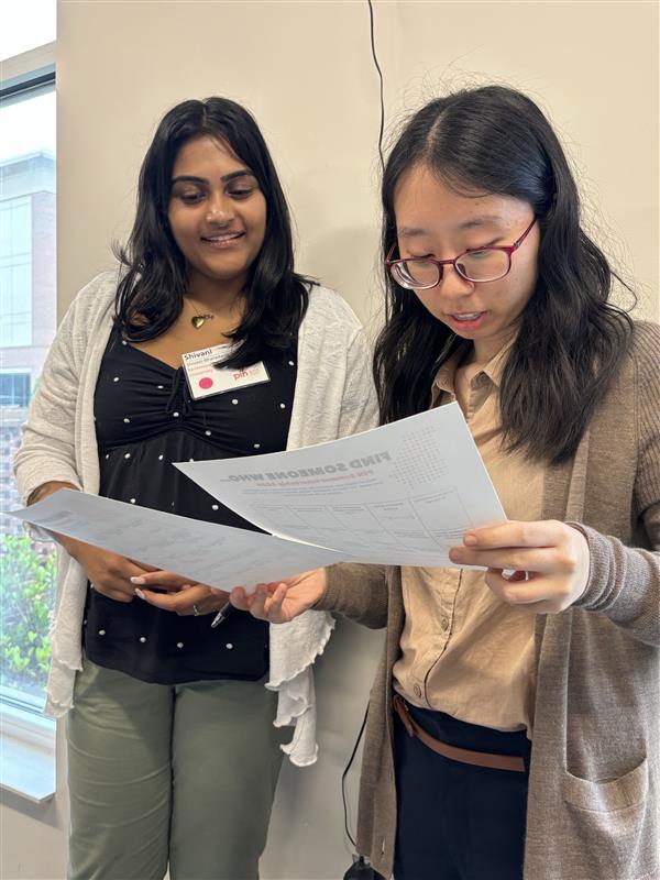 Two student interns review outlines.